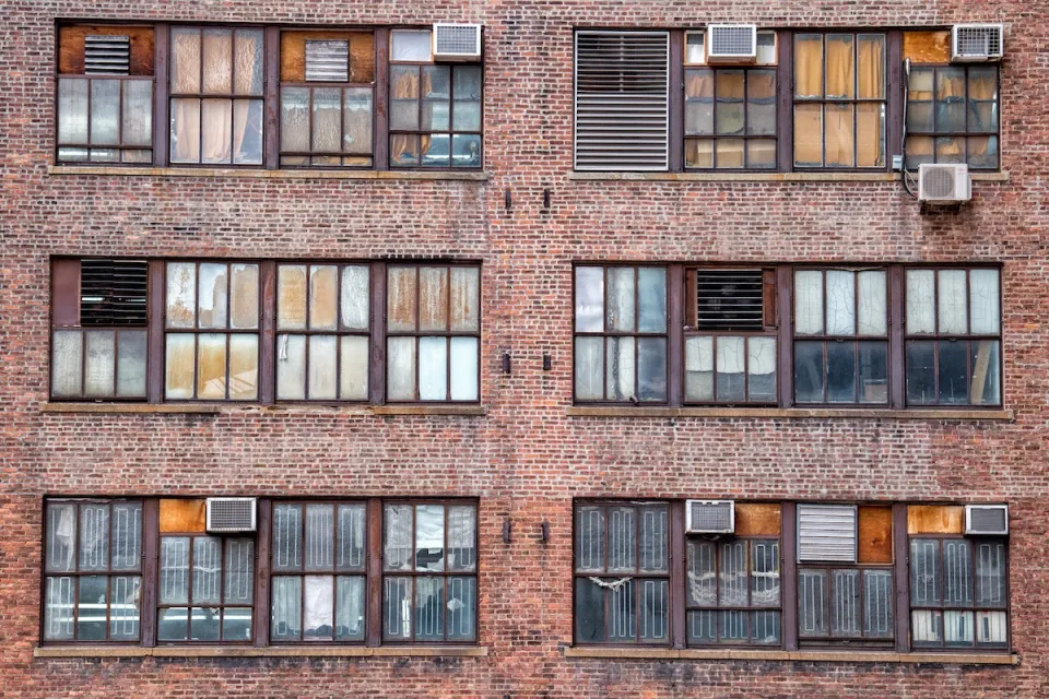 Manhattan brick apartments with AC units on windows.